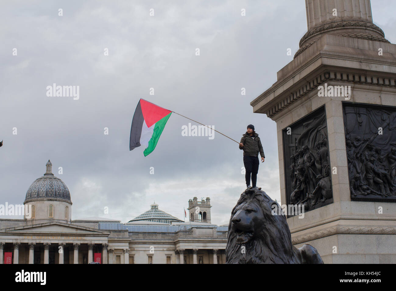 Un protestataire vagues le drapeau palestinien en vertu de la colonne Nelson sur le centenaire de la déclaration de Balfour, Trafalgar Square, Londres Banque D'Images