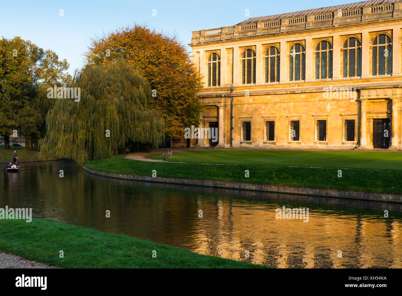 Vue panoramique de la bibliothèque Wren au coucher du soleil, le Trinity College, l'Université de Cambridge ; avec en face en barque sur la rivière Cam, au Royaume-Uni. Banque D'Images