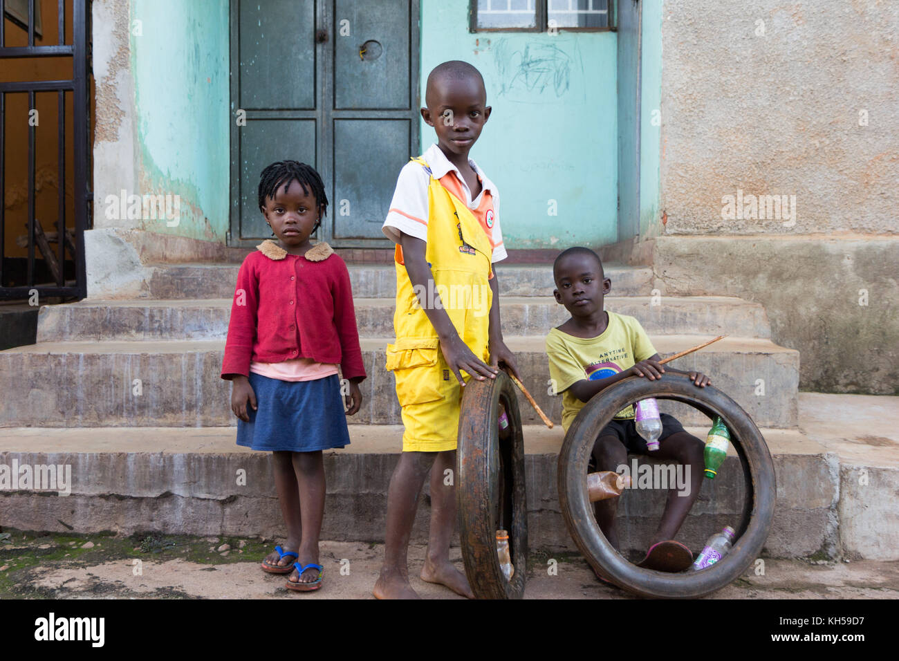 Les enfants ougandais jouant avec un simple jouet - un pneu d'une moto. Banque D'Images