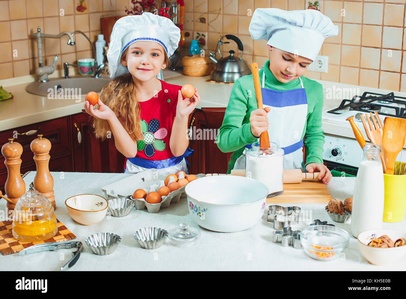 Happy Family funny kids sont la préparation de la pâte, faire cuire des biscuits dans la cuisine Banque D'Images