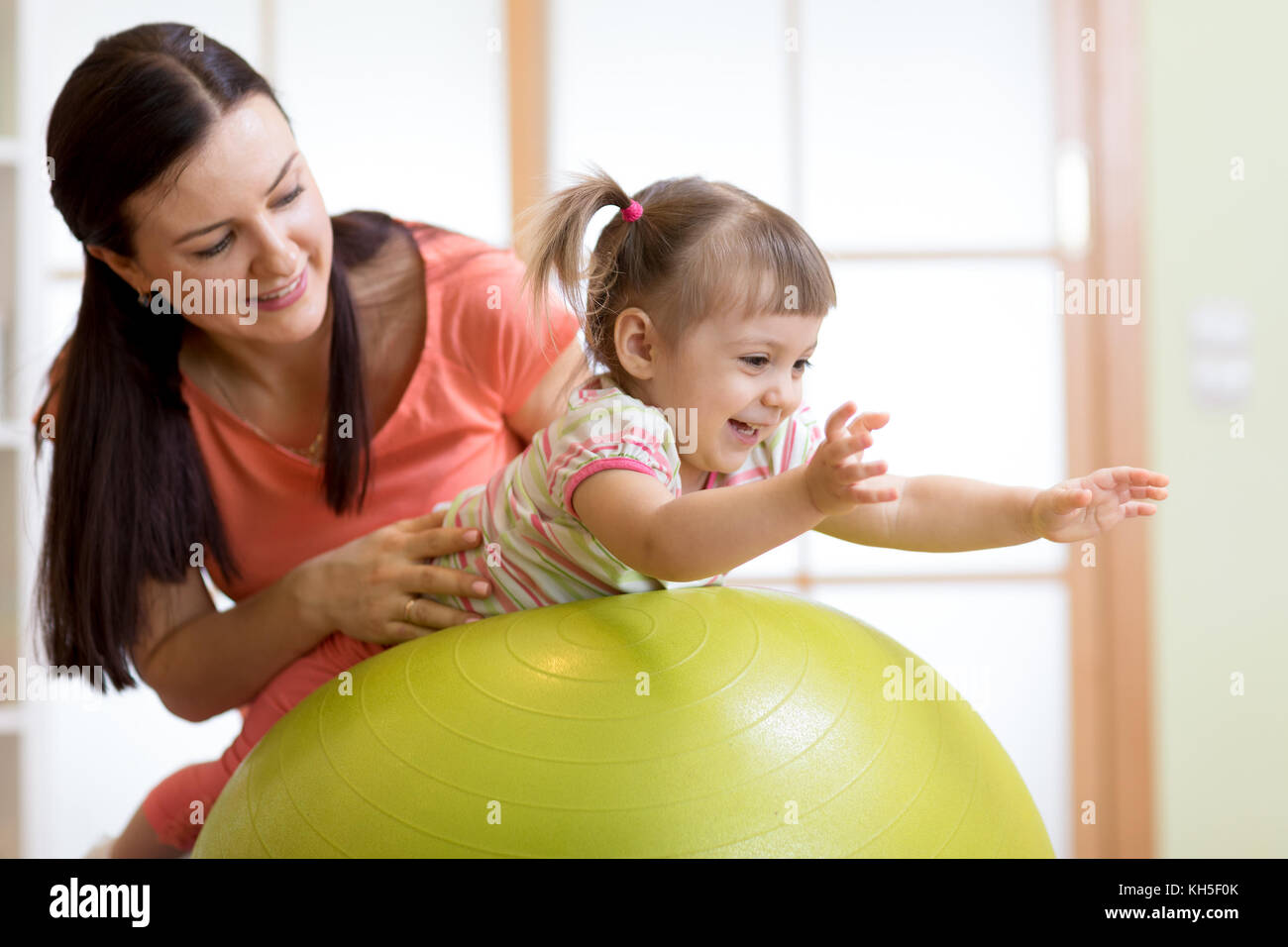 La mère et l'enfant jouant avec fitness ball Banque D'Images