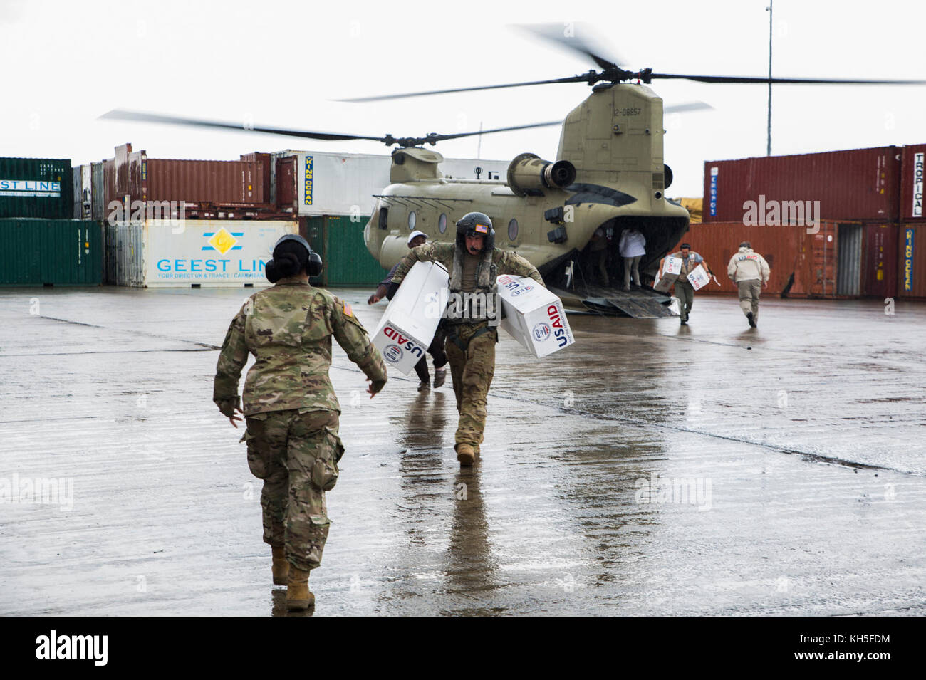 Les membres du service des États-Unis avec la Force opérationnelle - les îles sous le vent et les membres de l'Agence américaine pour le développement international de l'équipe d'intervention en cas de catastrophe de décharger les fournitures d'une armée américaine d'hélicoptères CH-47 Chinook au port de Roseau, Dominique, 30 septembre 2017. À la demande de l'USAID, la FOI-LI a déployé des avions et les membres de services d'aider les secours d'urgence vers la Dominique à la suite du cyclone Maria. Le groupe de travail est une unité militaire composée de Marines, soldats, marins et aviateurs, et représente le principal Commandement Sud des États-Unis suite à l'ouragan que le VHA Banque D'Images
