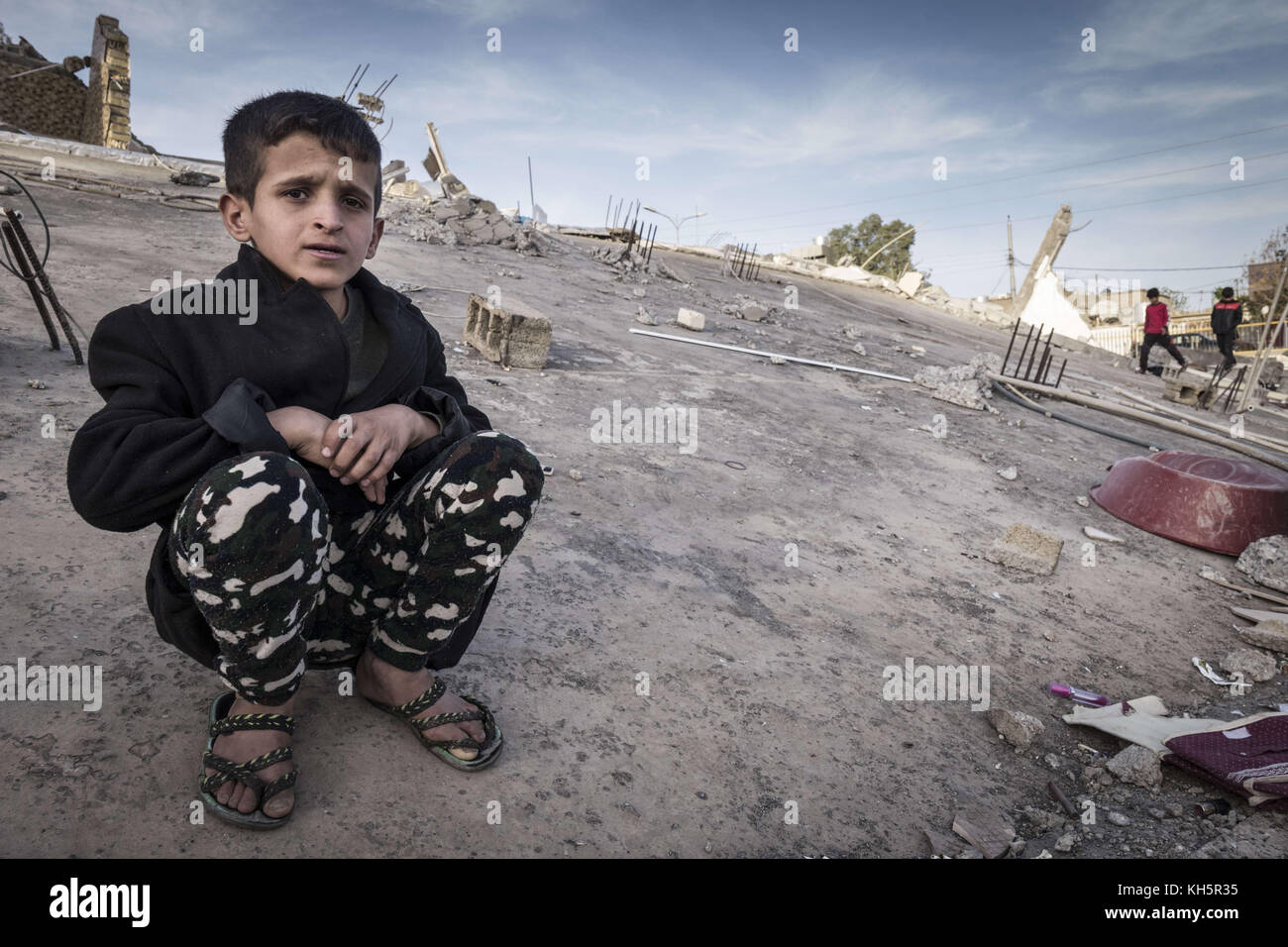 Darbandixan, région gouvernementale régionale du Kurdistan, Irak. 13 novembre 2017. Un garçon est assis au sommet d'un bâtiment endommagé après un tremblement de terre qui a frappé plus tôt. Un puissant tremblement de terre de magnitude 7,3 qui a frappé dimanche la région frontalière entre l'Iran et l'Irak a tué au moins 395 Iraniens, a rapporté lundi la télévision d'État. Crédit : Berci Feher/ZUMA Wire/Alamy Live News Banque D'Images