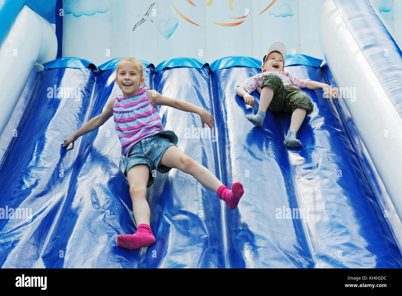 Les enfants jouent avec bonne humeur dans les toboggans gonflables amusement park Banque D'Images