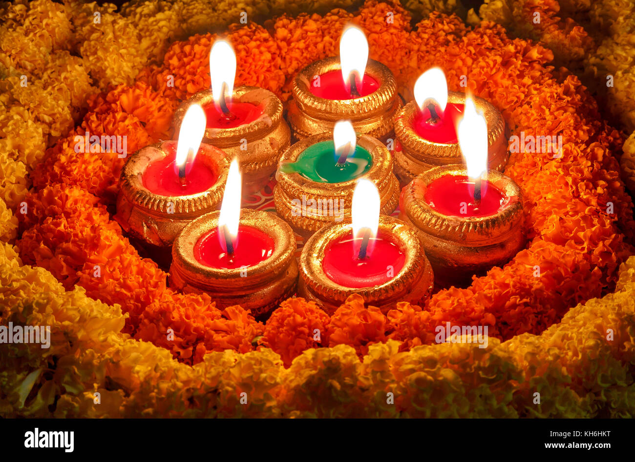 L'argile du Diwali diya lampes avec des décorations florales en fond sombre Banque D'Images