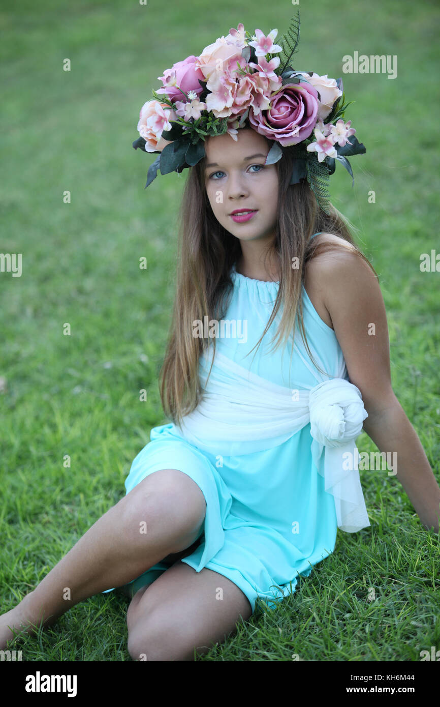 Une belle jeune fille de 12 ans habillé dans une robe bleu clair, portant une couronne de fleurs portefeuille bat mitzvah. Banque D'Images