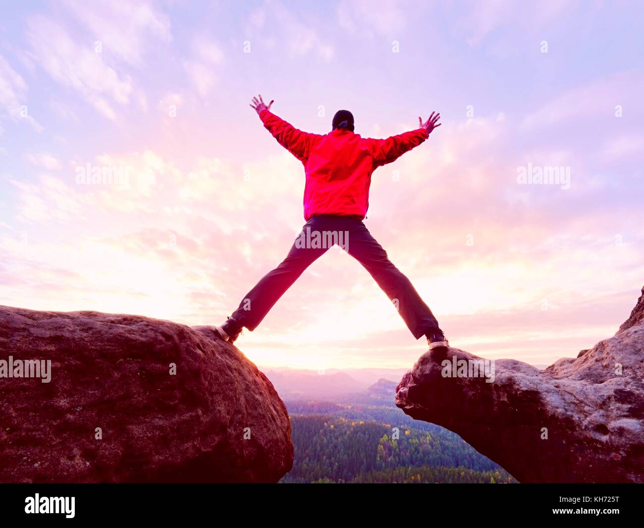 Man de la montagne. Homme de sauter d'une falaise sans corde. Moment risqué. Rough terrain rocheux. Banque D'Images