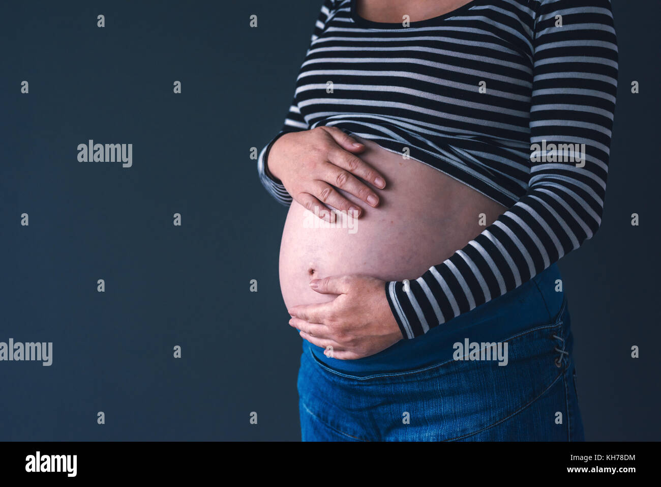 L'amour doux femelle enceinte avec les mains sur son ventre dans le troisième trimestre de la grossesse s'attendant bébé nouveau-né Banque D'Images
