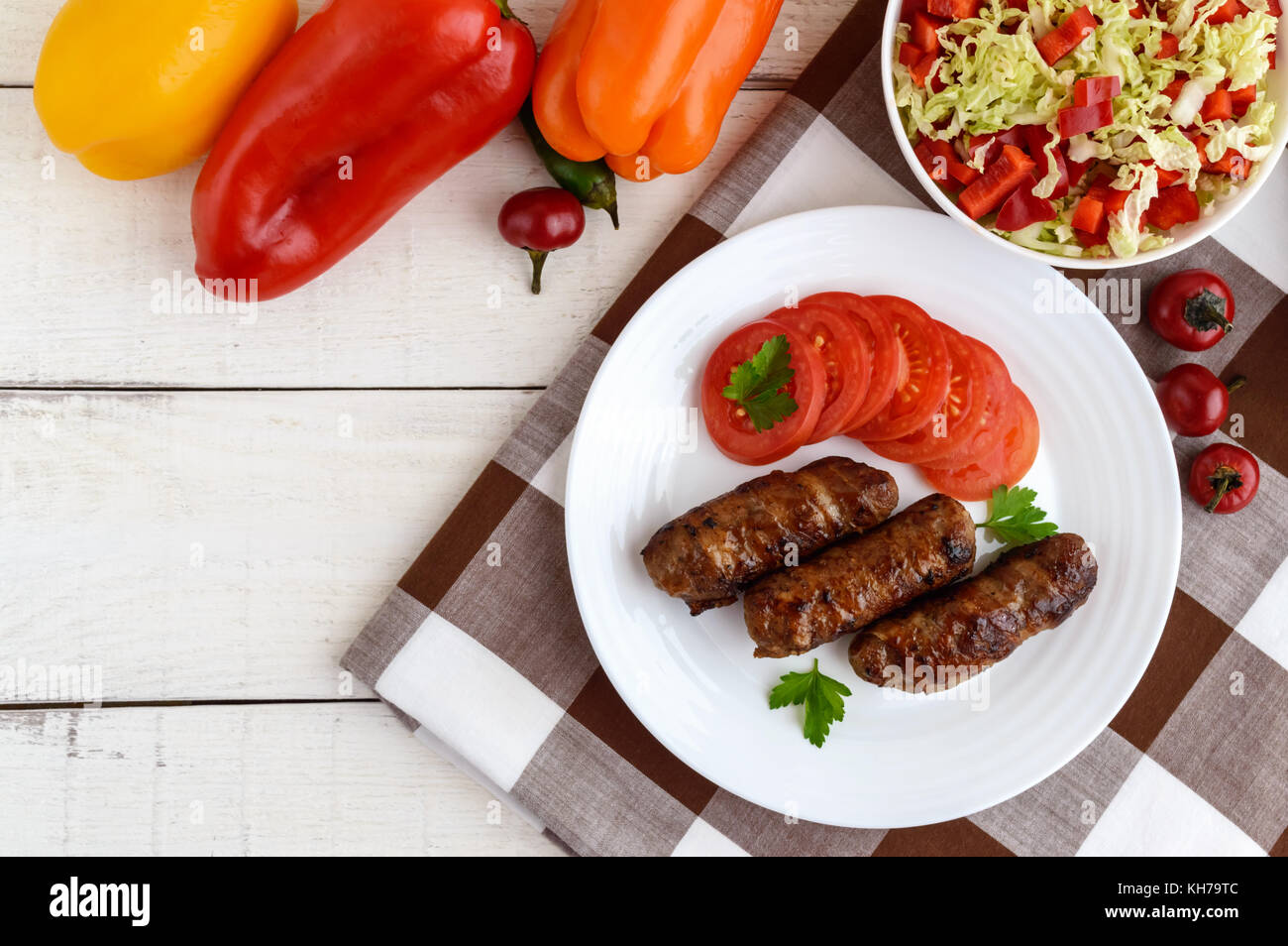 Rouleaux grillé juteux de viande hachée enrobé de bacon avec tomates fraîches et une légère