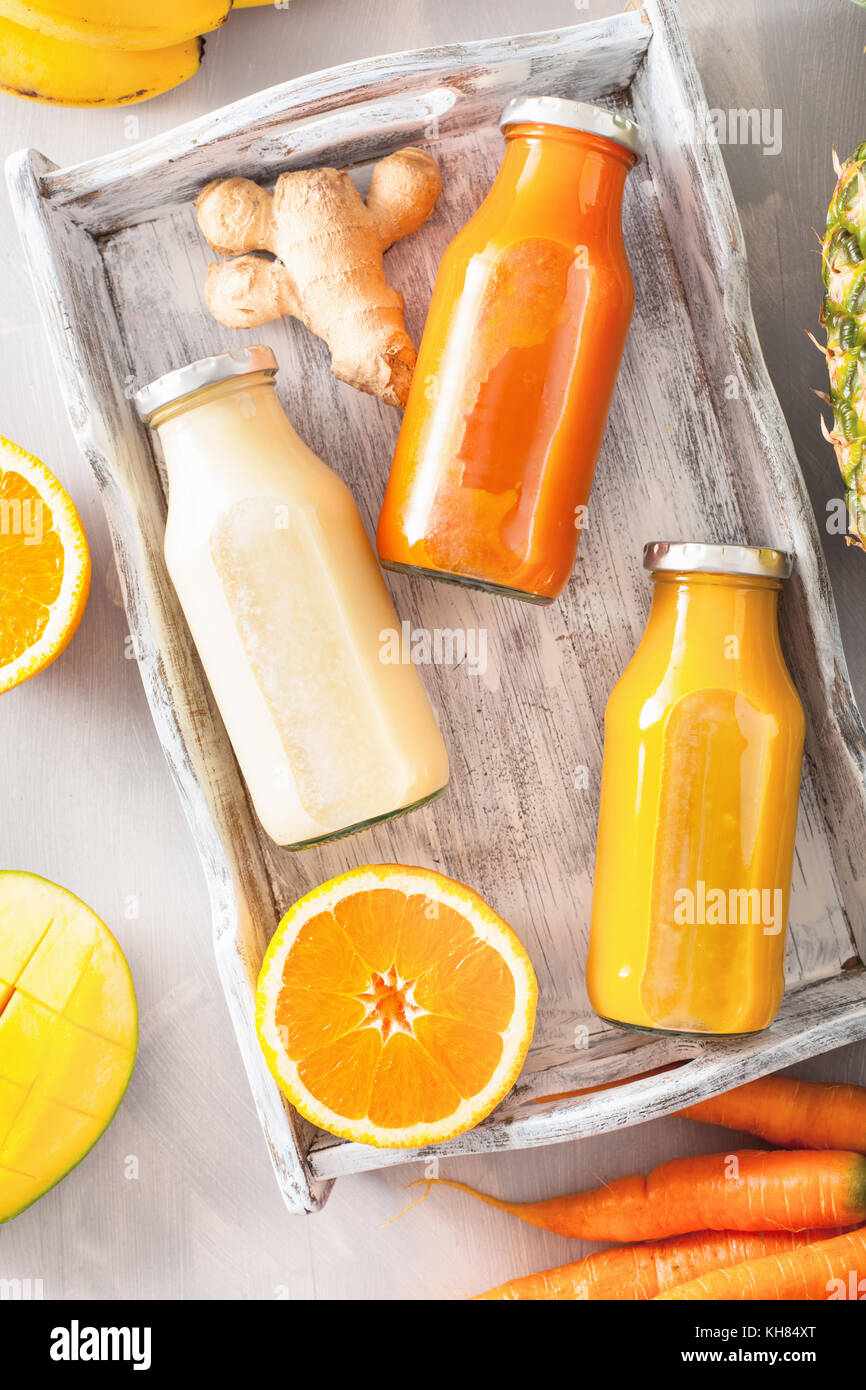 Des smoothies de fruits et légumes dans des bocaux en verre, orange carotte banane mangue ananas Banque D'Images