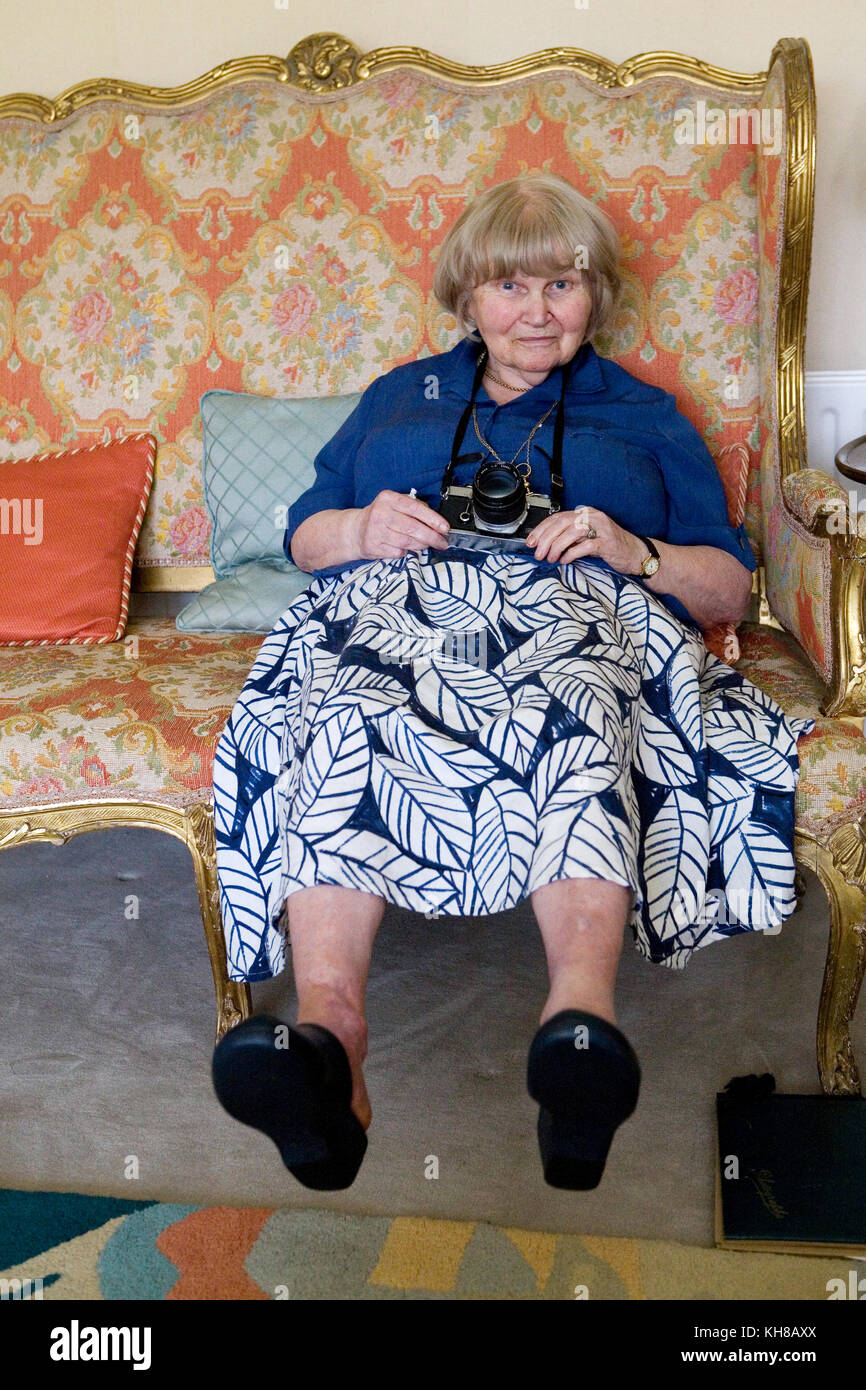 Photographe Jane Bown (13 mars 1925 - 21 décembre 2014), Woman sitting on sofa holding camera Banque D'Images