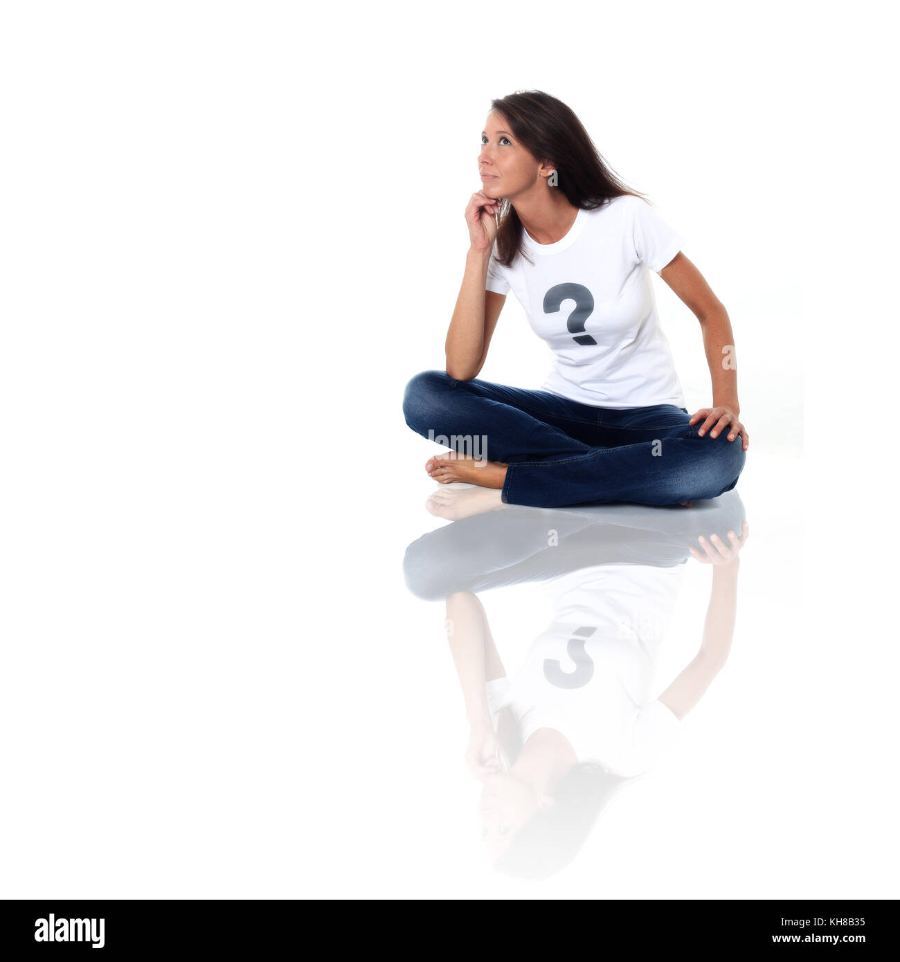 Femme brune en studio portant un tee shirt avec un point d'interrogation et de l'air pensif. conceptual image sur le thème "né sous x" Banque D'Images
