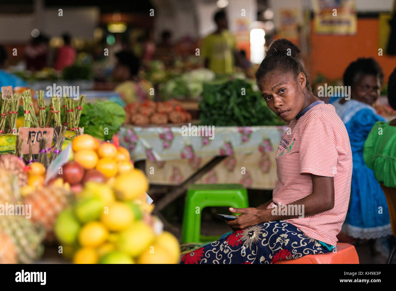 Jeune femme assise avec son ananas téléphone mobile, Port Vila, marché de fruits et légumes. Vanuatu. Banque D'Images