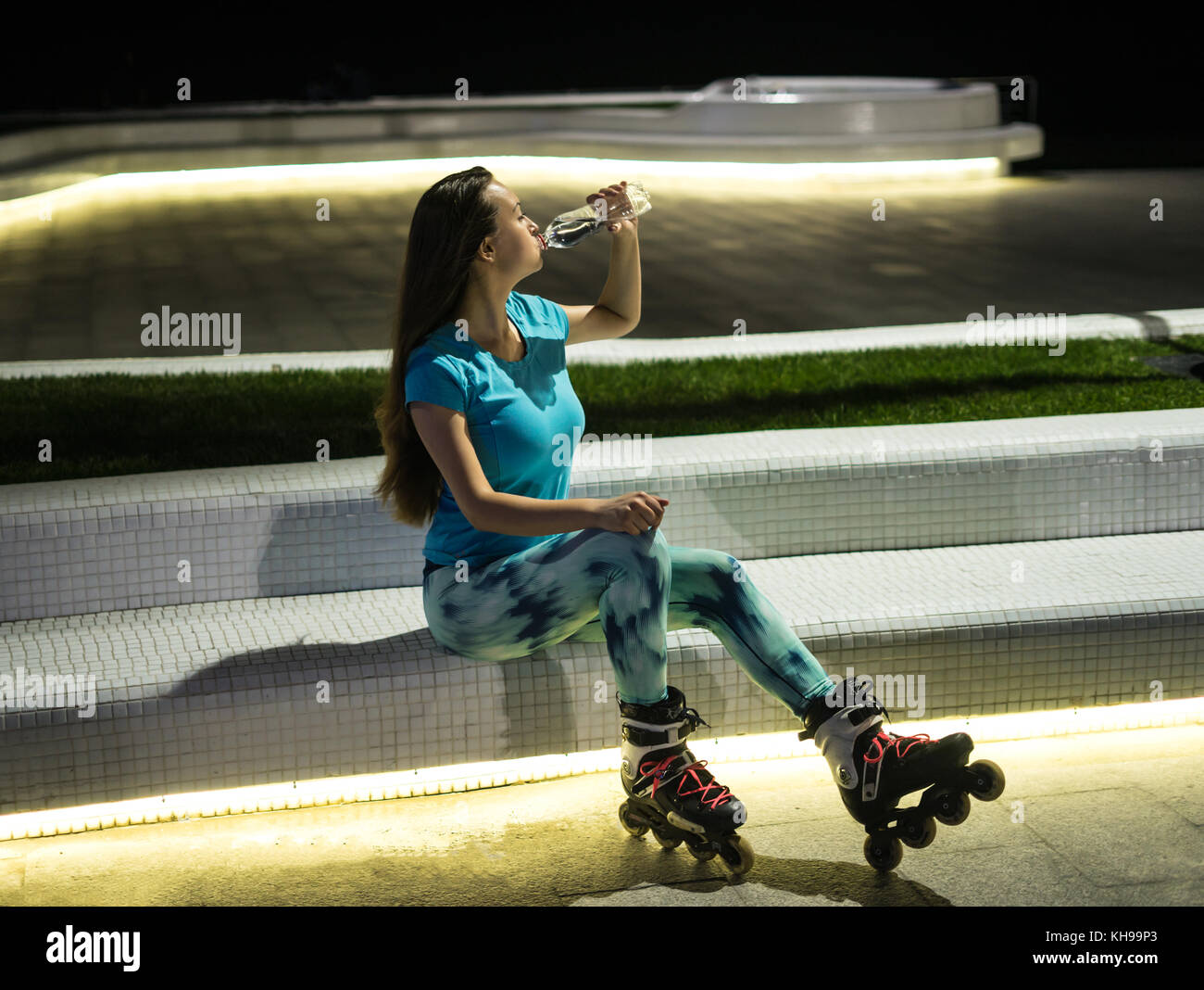 Roller girl est l'eau potable de la bouteille en plastique Banque D'Images