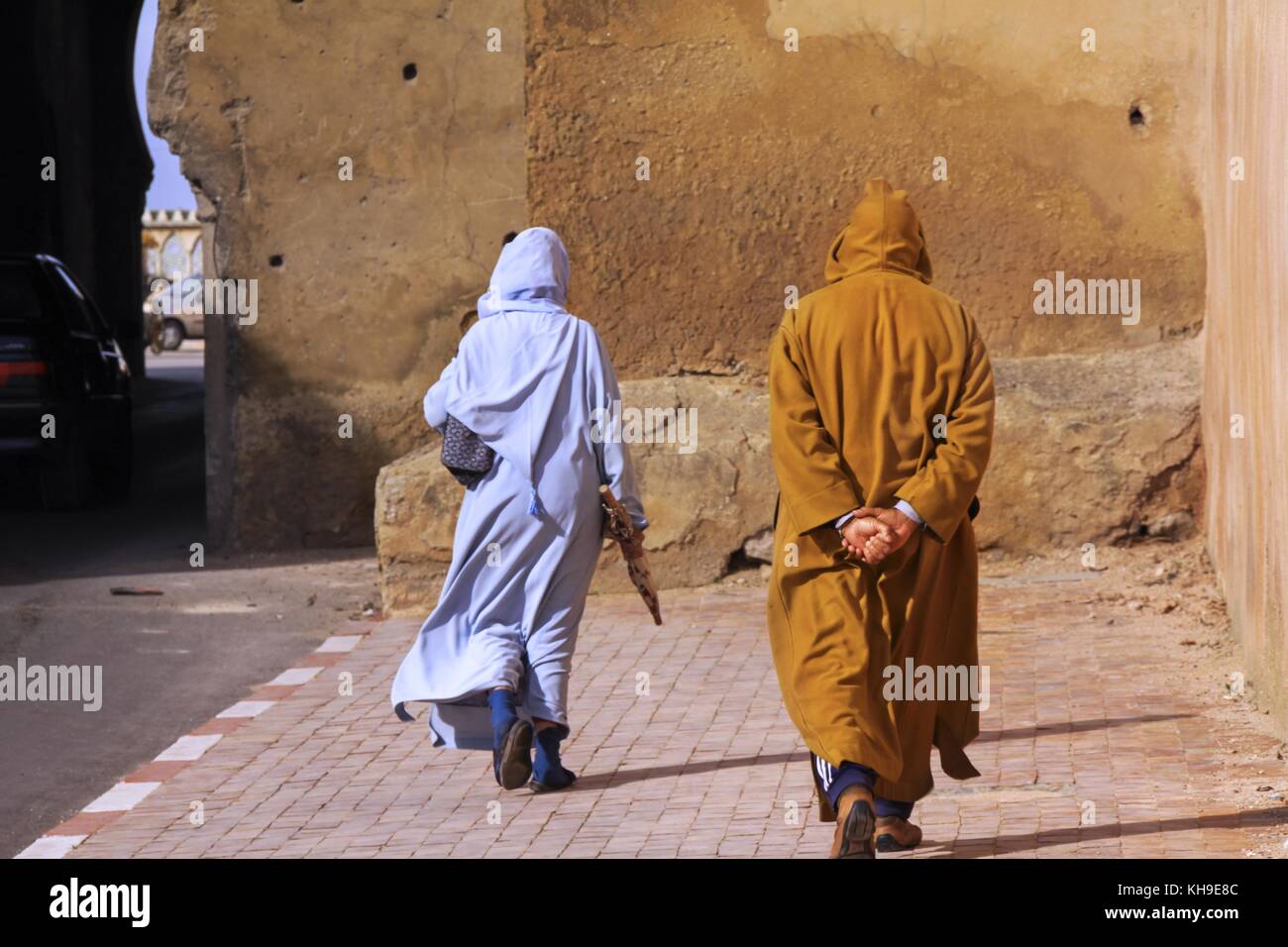 Arab Street Walkers vêtus de style traditionnel marocain à longue capuche Vêtements à manches pleines dans les rues de Casablanca Maroc Banque D'Images