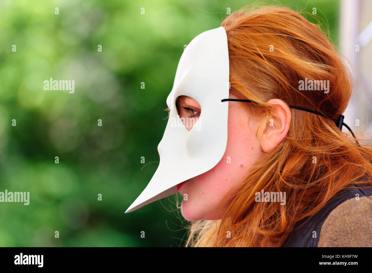 Libre d'une interprète féminine aux cheveux rouges portant un masque sur le Royal Mile, au cours de l'Edinburgh International Fringe Festival Banque D'Images