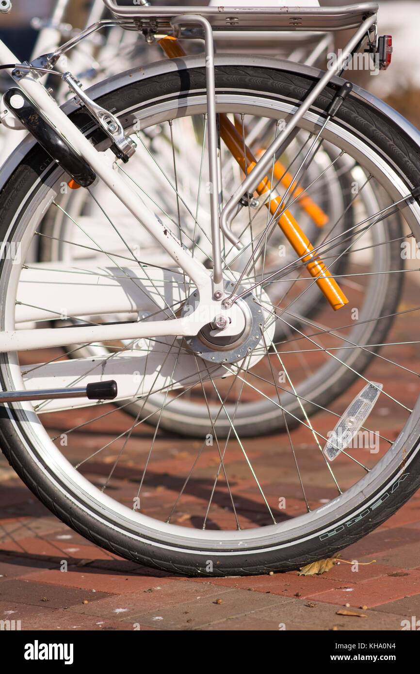 Vélo pneus alignés dans une rangée à la station de location. Banque D'Images
