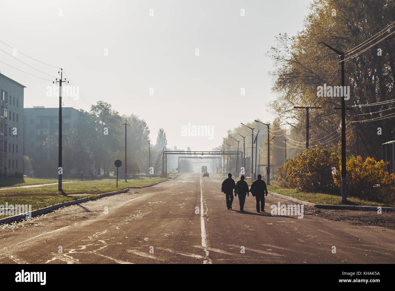Trois hommes marche sur la route un matin au travail à Tchernobyl, en Ukraine Banque D'Images