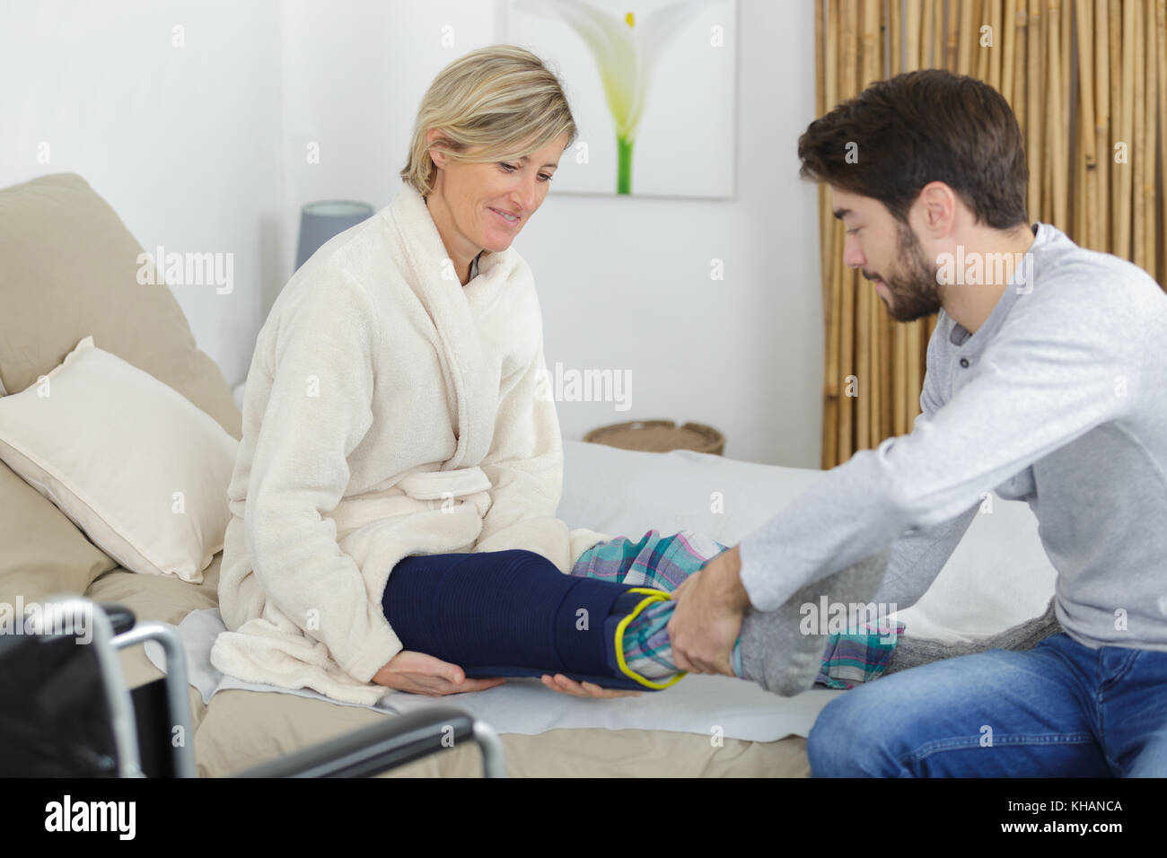 Patient avec jambe cassée au lit avec l'aide Banque D'Images