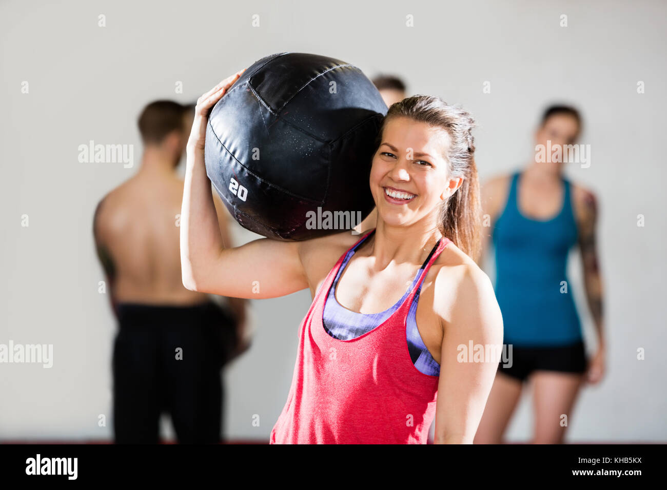 Portrait of smiling female trainer exerçant son ballon d'une salle de sport Banque D'Images