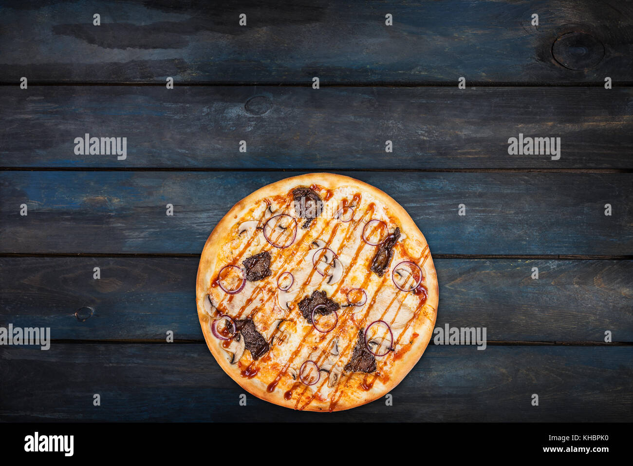 Délicieuse pizza aux champignons, viande de poulet et les oignons sur un fond de bois foncé. haut voir le fond d'orientation. Banque D'Images