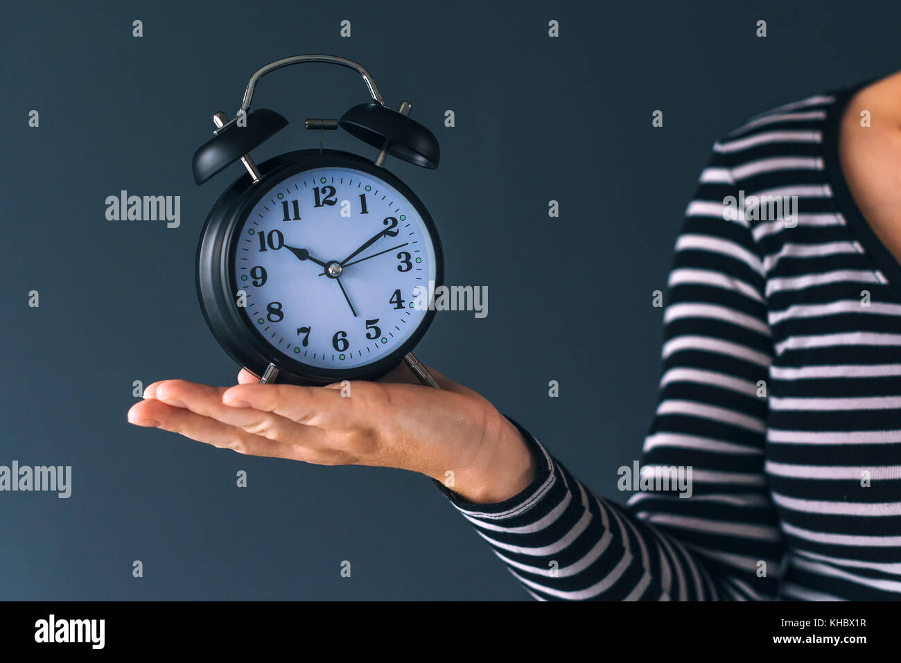 Le temps passe, femme hand holding vintage noir élégant réveil, selective focus Banque D'Images