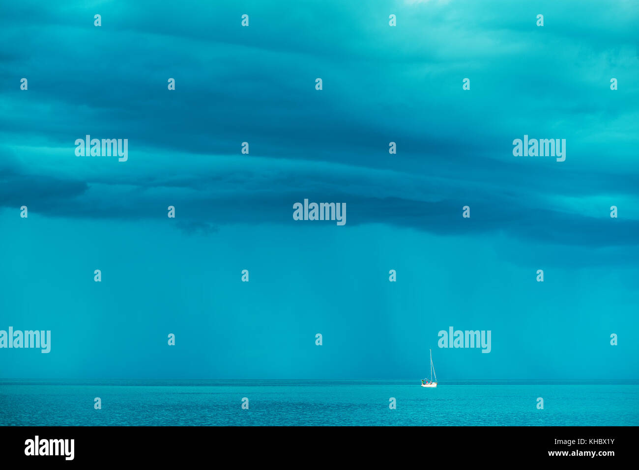 Bateau à voile à l'horizon de mer houleuse avec des nuages de pluie en arrière-plan Banque D'Images