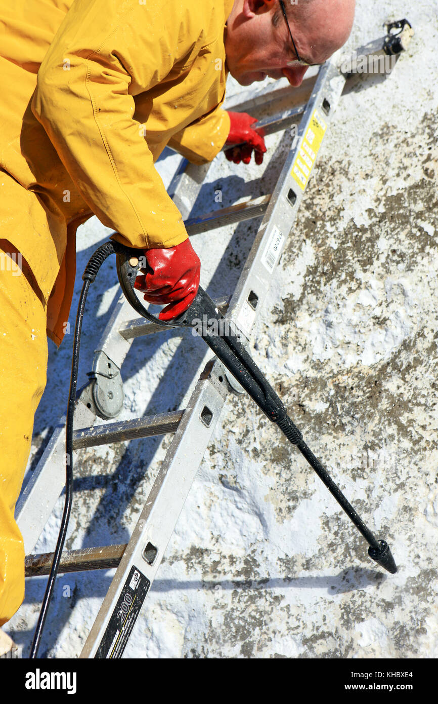 L'homme à l'aide d'un nettoyeur haute pression pour décaper la peinture de  la fin d'un gable cottage Photo Stock - Alamy