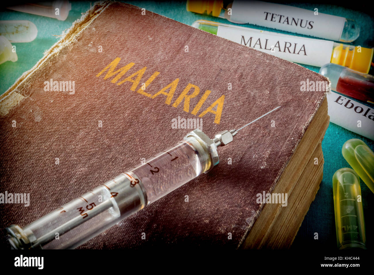 Seringue vintage sur un livre de paludisme, concept médical Banque D'Images