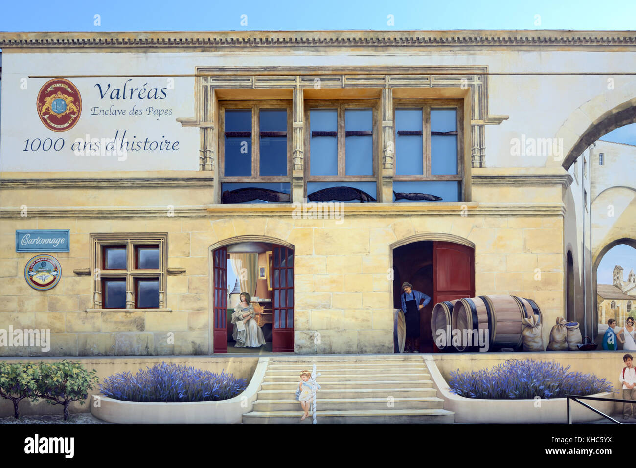 Peinture murale trompe l'œil, ancien bâtiment de la gare, avec des fûts de vin ou un vignoble, et fausse architecture médiévale, Valreas, Provence, France Banque D'Images