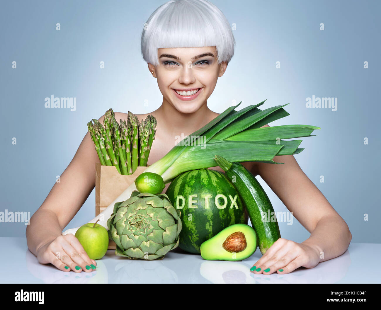 Smiling girl avec une abondance de fruits et légumes. photo de jeune fille blonde sur fond bleu. concept de vie sain Banque D'Images