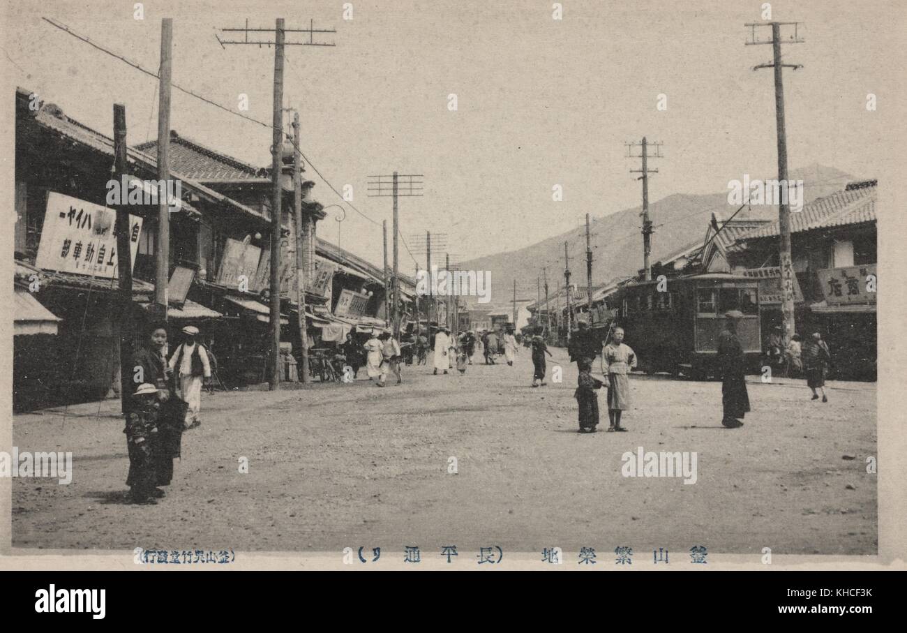 Carte postale marquée main Street, Fusan, avec des personnes marchant le long d'une route de terre bordée de magasins, Busan, Corée du Sud, 1922. De la bibliothèque publique de New York. Banque D'Images