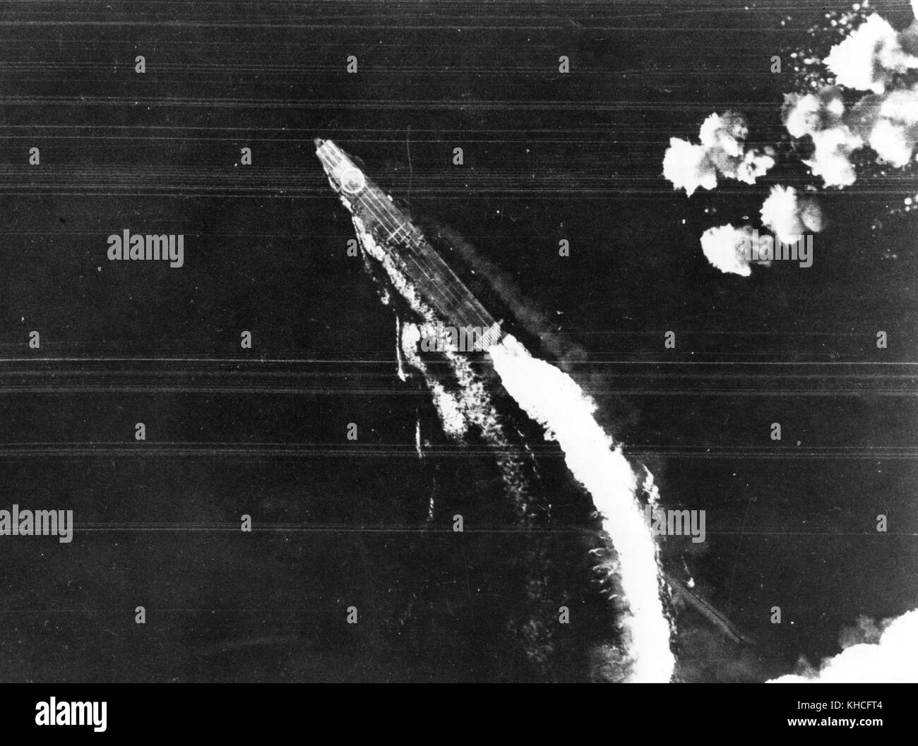 Le porte-avions japonais Hiryu manoeuvres pour éviter les bombes lancées par l'USAAF Boeing B-17F Flying Fortress bombers pendant la bataille de Midway, peu après 8 h, le 4 juin 1942. Remarque la grande hinomaru marque d'identification sur l'arc, le caractère d'identification Katakana 'hi' sur son poste de pilotage, et après au moins trois avions sur le pont. Banque D'Images