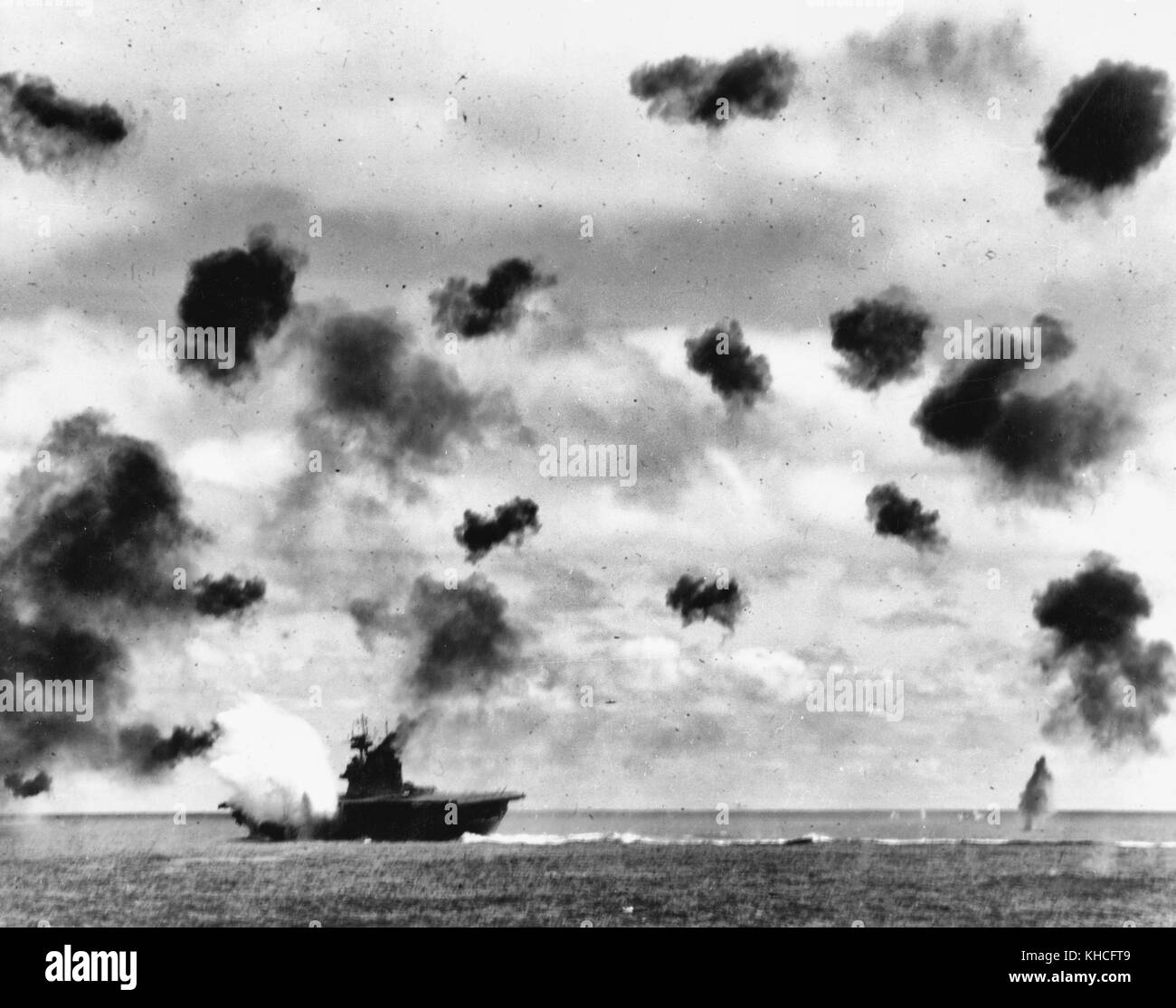USS Yorktown (CV-5) est frappé sur le côté bâbord, au milieu du navire, par une torpille aérienne Type 91 Japonais en milieu d'après-midi l'attaque par les avions de l'Hiryu transporteur, dans la bataille de Midway, le 4 juin, 1942. Yorktown est au port de gîte et est vue à un aspect différent que dans d'autres vues prises par le USS Pensacola (CA-24), indiquant qu'il s'agit de la deuxième des deux torpedo hits qu'elle a reçu. Remarque très lourd anti-aériens. Banque D'Images