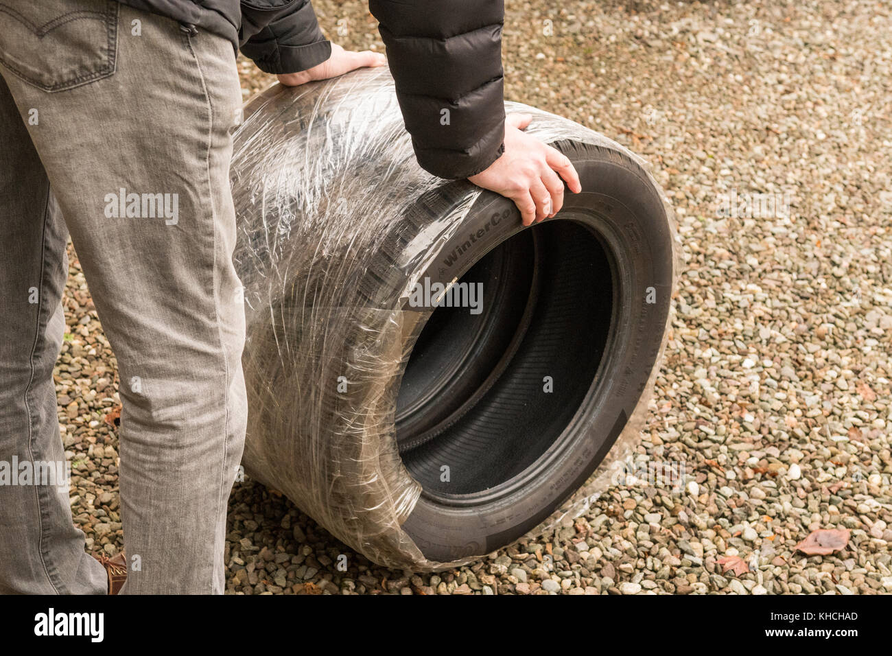 Homme prenant des pneus d'hiver à monter sur un véhicule prêt pour l'hiver - Écosse, Royaume-Uni Banque D'Images