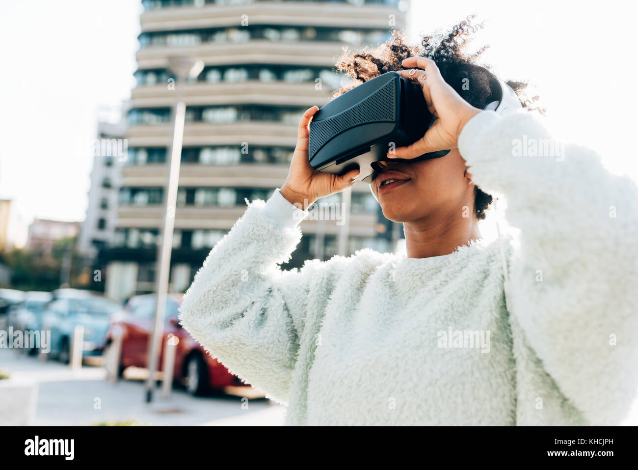 Portrait de jeune femme belle à l'aide d'une visionneuse 3D dans la ville lumière arrière - technologie, jeu vidéo, concept futuriste - filtré colorés Banque D'Images