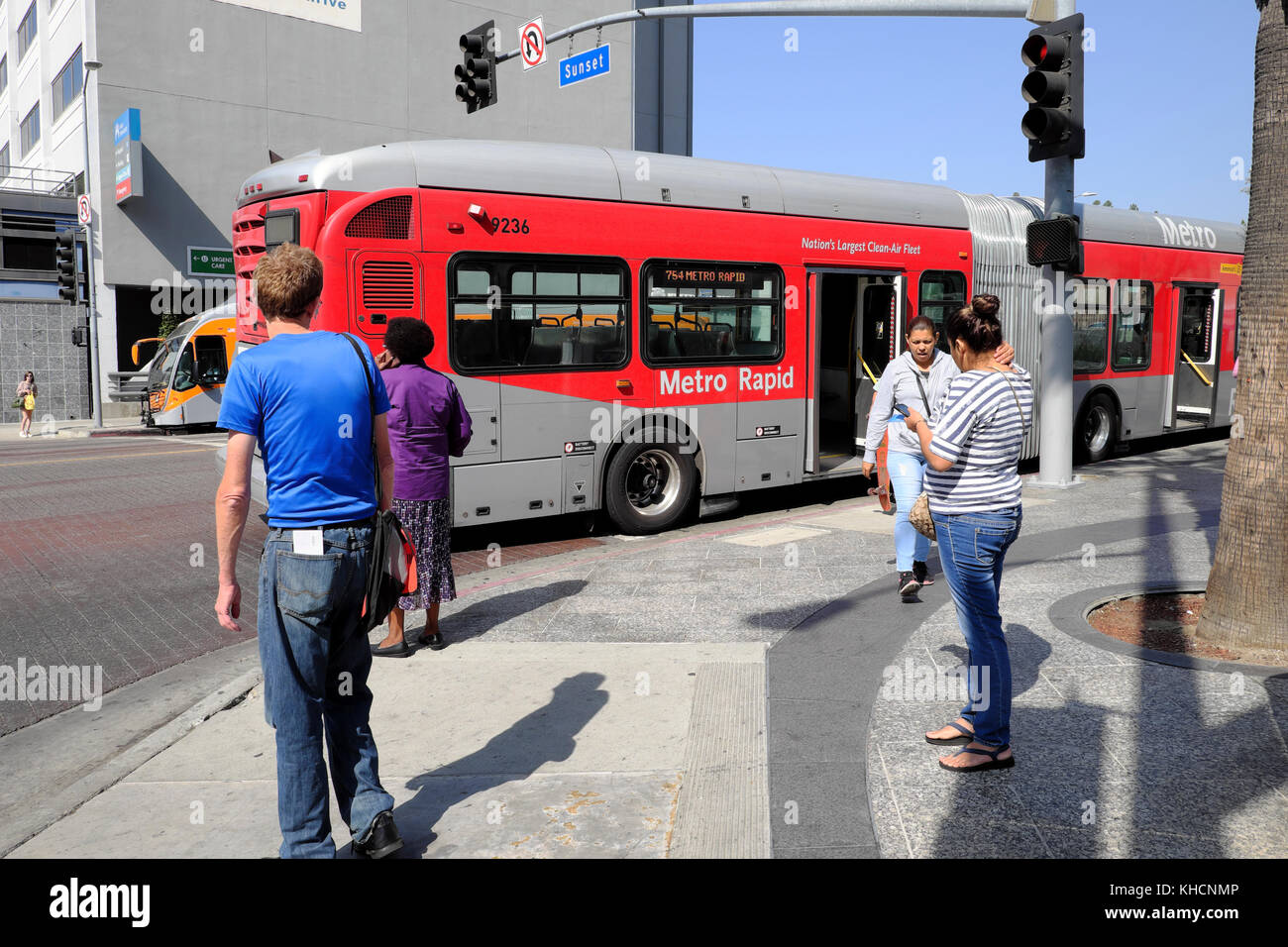 Metro bus rouge rapide et les piétons à l'angle de Sunset Boulevard et Boulevard à Los Angeles, California USA KATHY DEWITT Banque D'Images