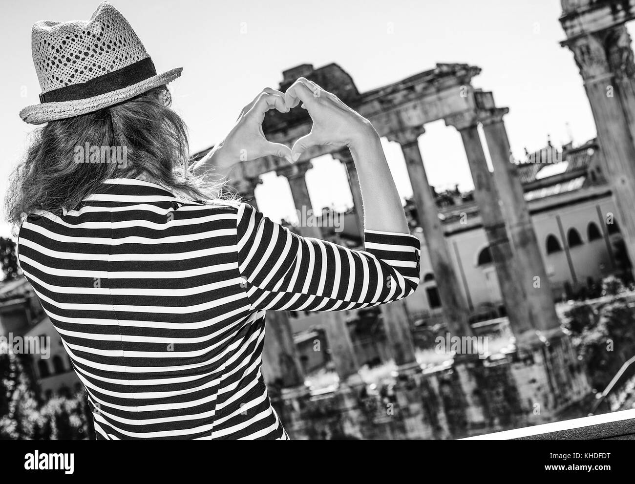 Vacances romaines. vu de dos trendy femme touristique à Rome, Italie montrant les mains en forme de coeur Banque D'Images