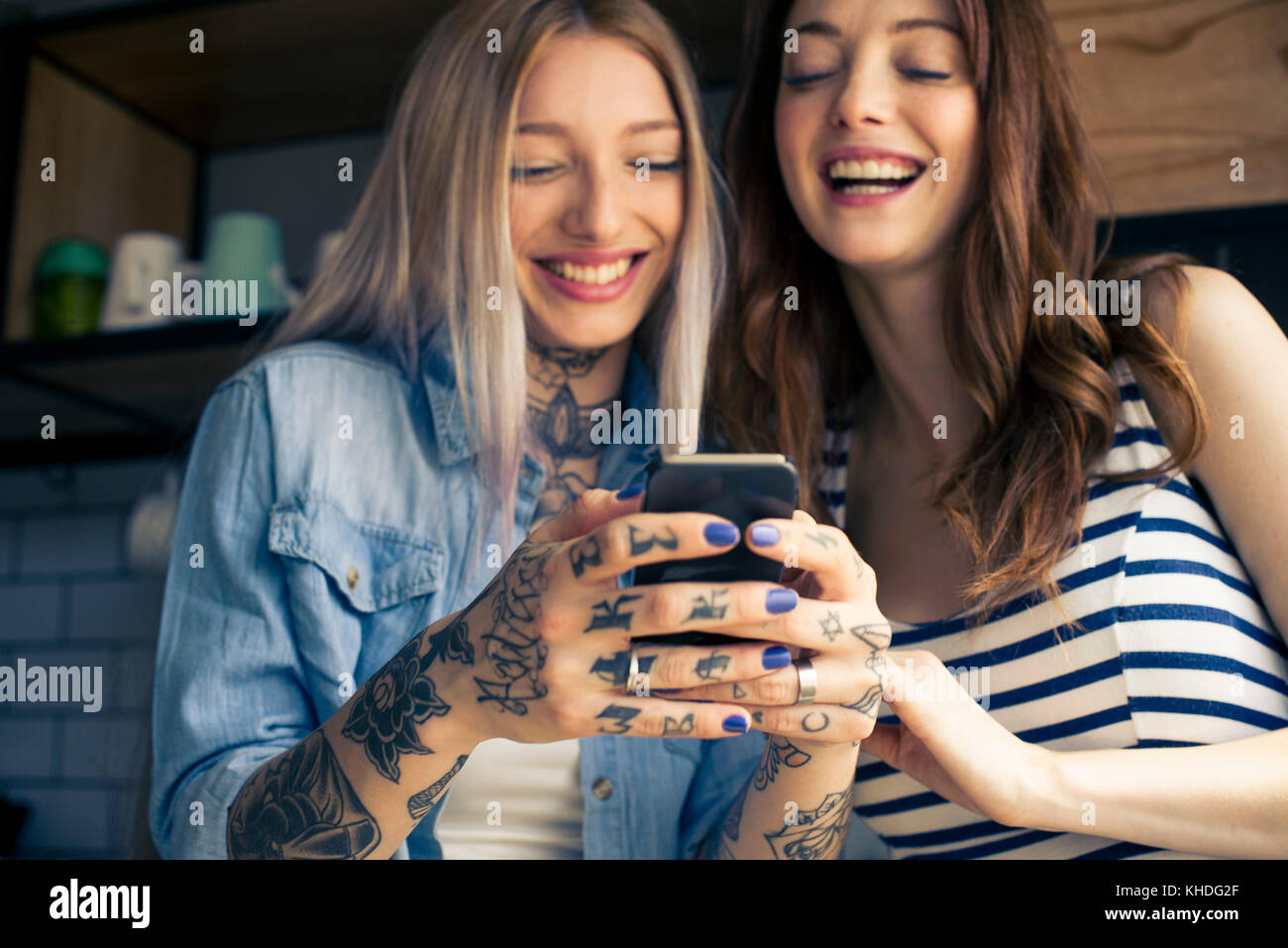 Women looking at smartphone et rire ensemble Banque D'Images