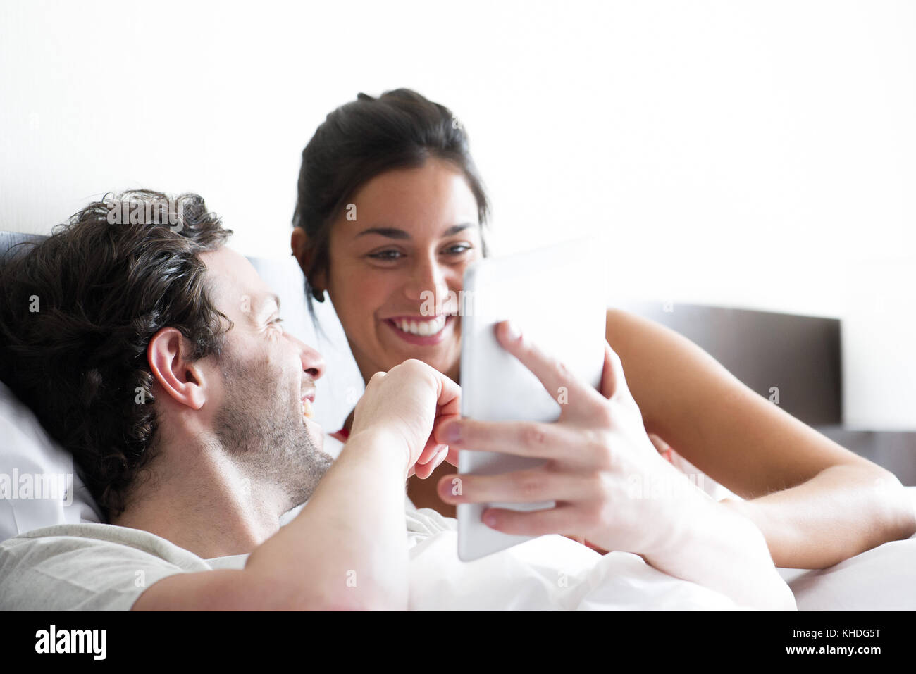 Couple using digital tablet in bed Banque D'Images