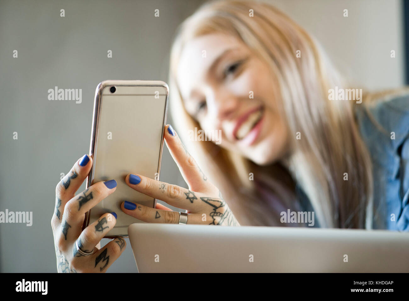 Woman holding smartphone and smiling Banque D'Images
