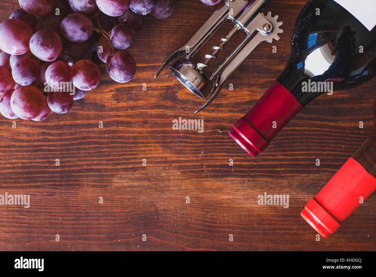 Arrière-plan de vin, vue de dessus deux bouteilles, tire-bouchon et d'un bureau en bois foncé sur raisin Banque D'Images