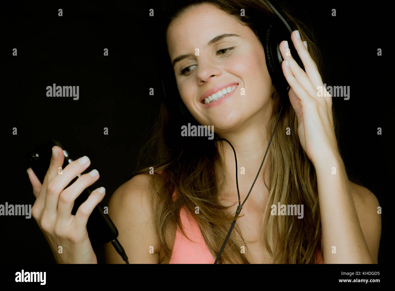 Young woman using smartphone et listening to headphones Banque D'Images