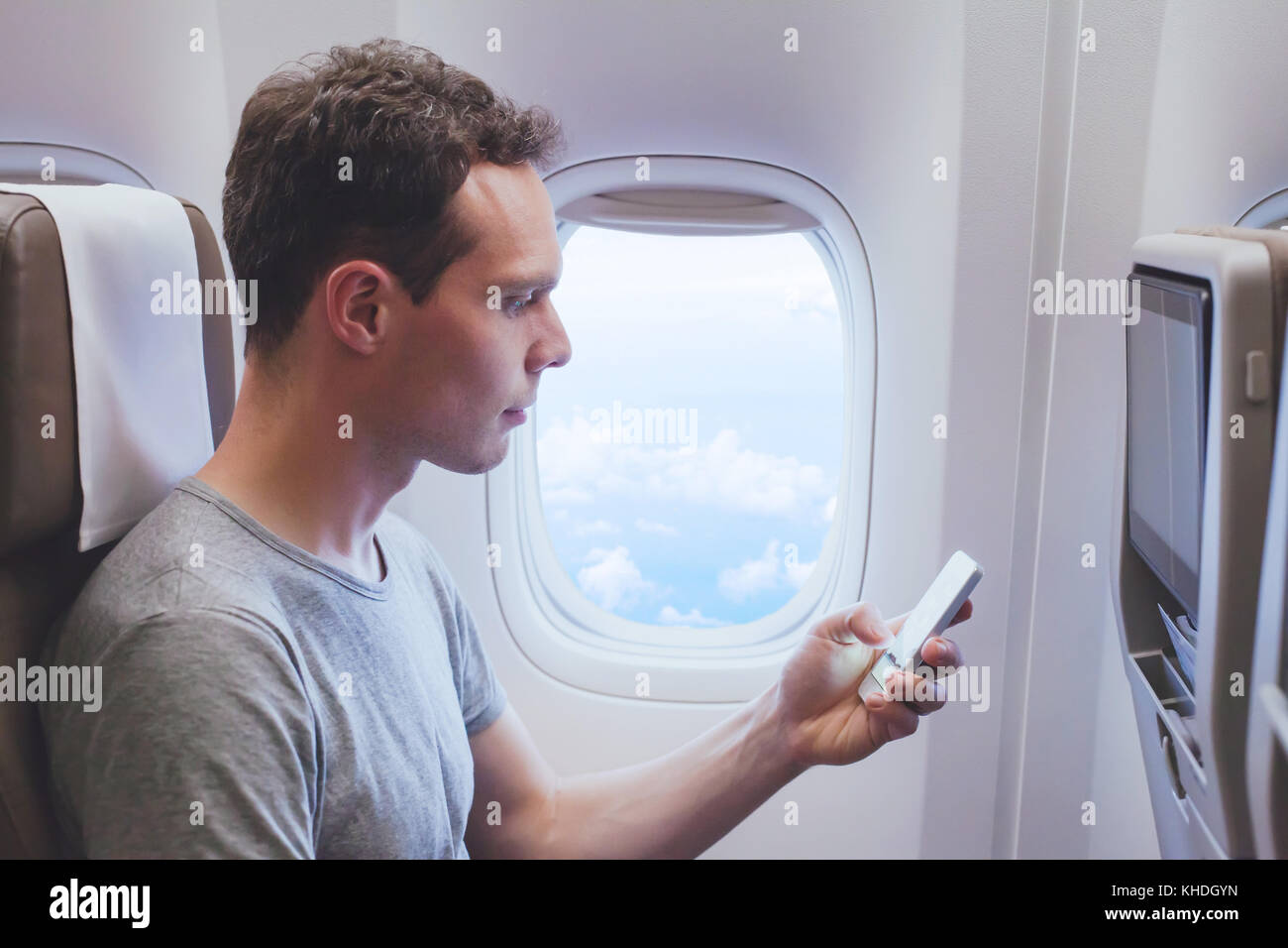 Passager utilisant smartphone téléphone mobile dans l'avion, connexion wifi dans l'avion pendant le vol. Banque D'Images