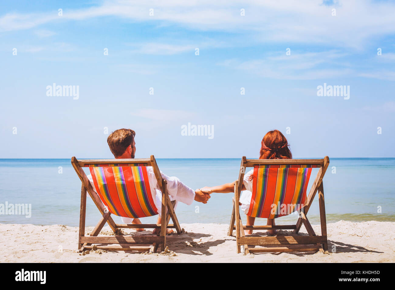 Couple assis dans des chaises longues sur la plage paradise, résumé, l'hôtel voyage vacances romantiques Banque D'Images