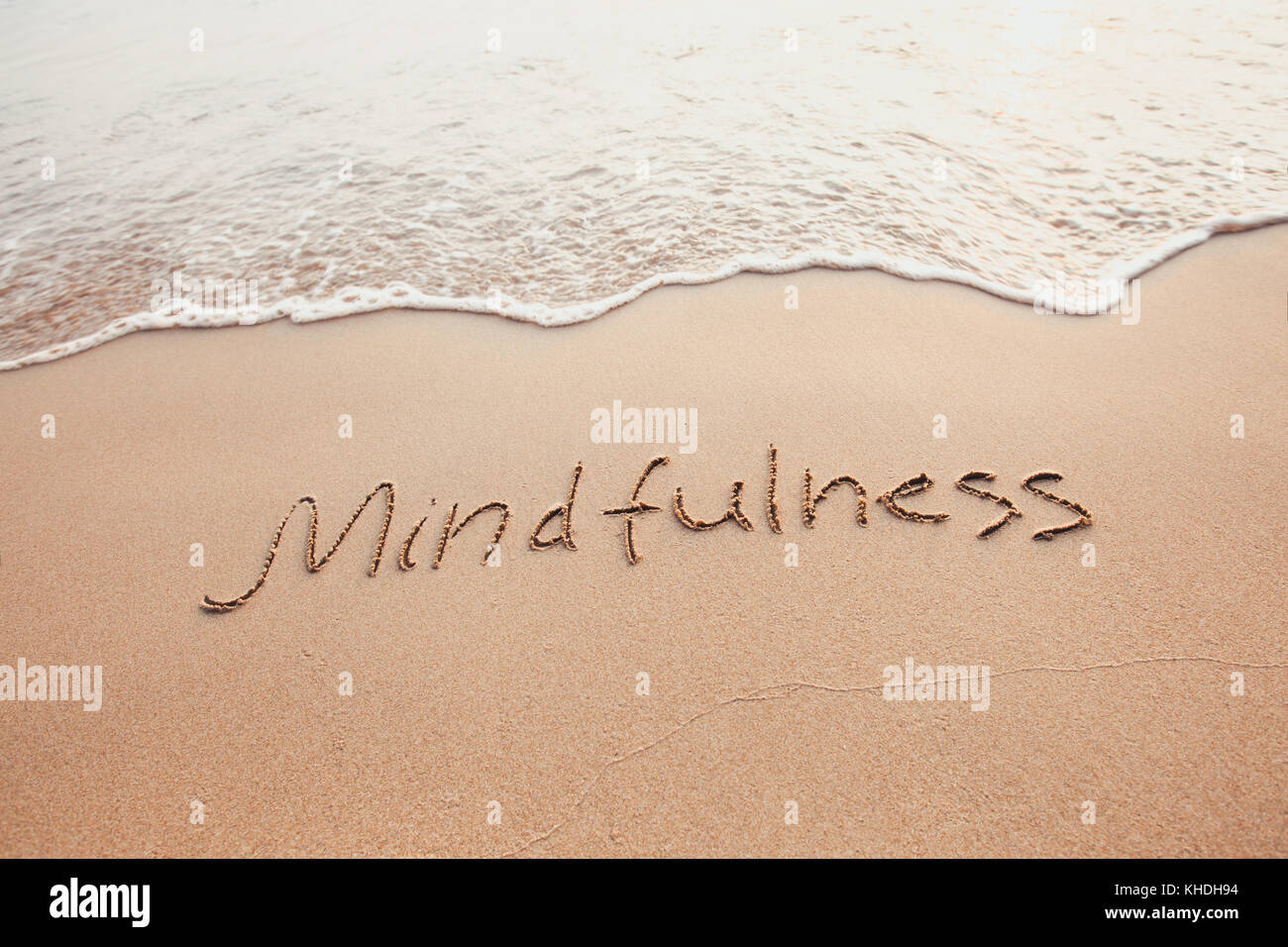Concept de mindfulness, conscient vivant, du texte écrit sur le sable de plage Banque D'Images
