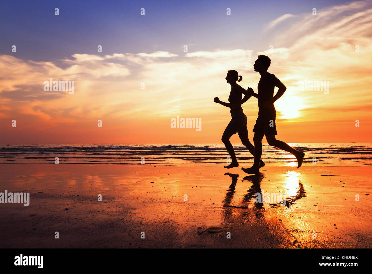 Contexte d'exécution, le sport et d'entraînement, des silhouettes de personnes jogging at sunset beach Banque D'Images