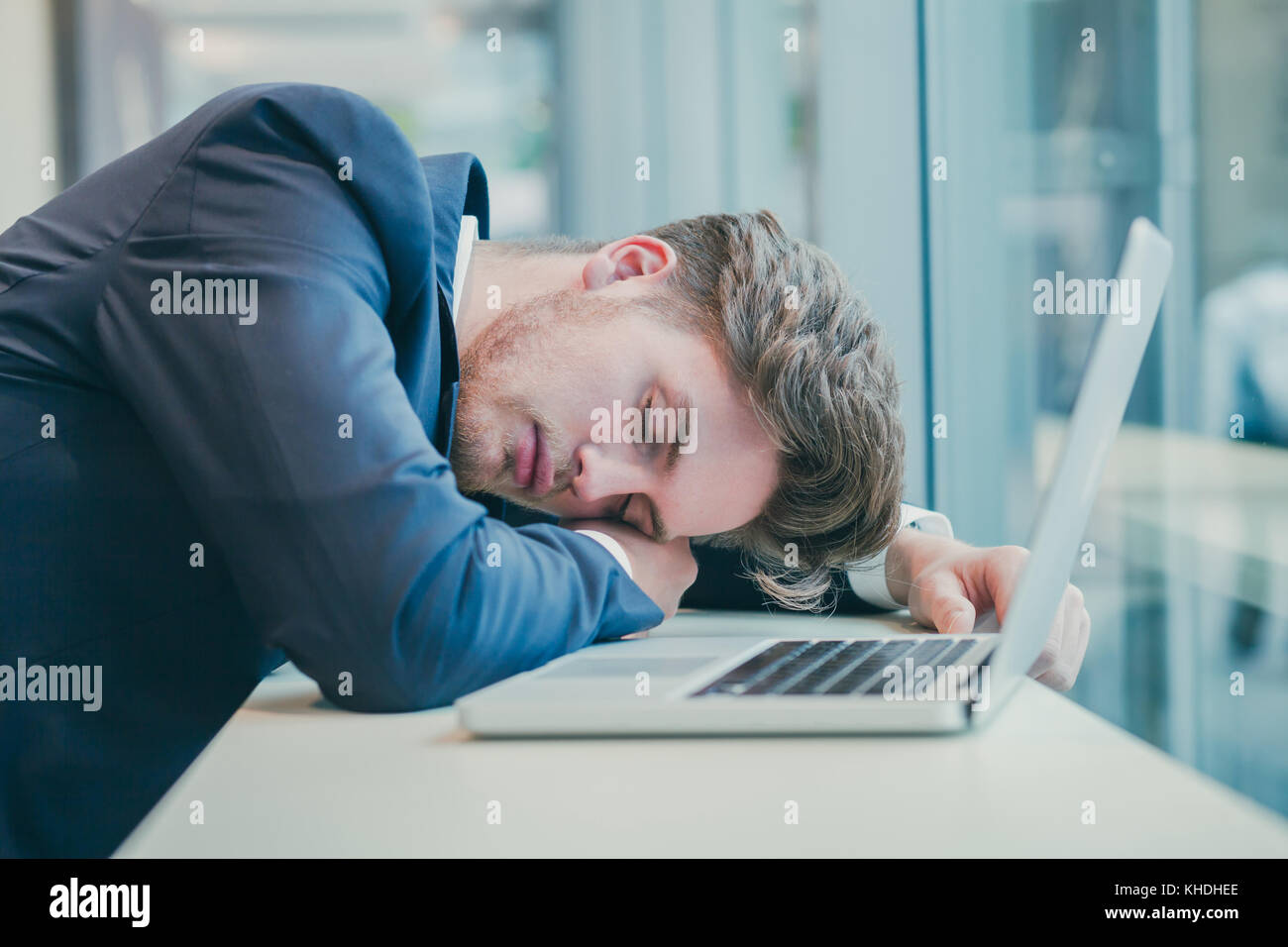 Fatigué businessman sleeping près de l'ordinateur Banque D'Images