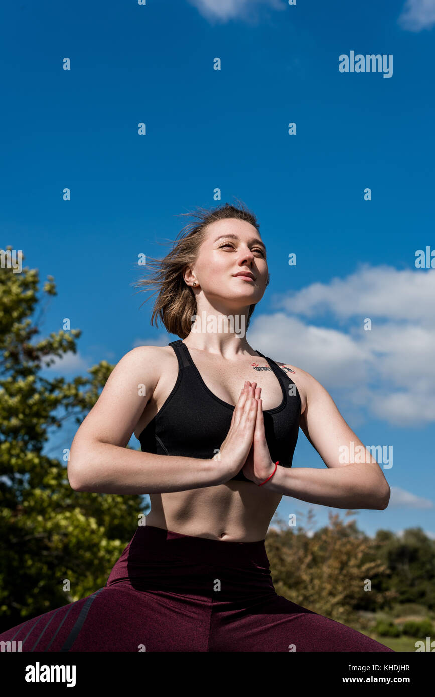 Woman practicing yoga outdoors Banque D'Images