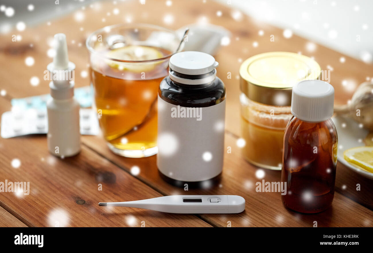 La drogue, thermomètre, le miel et une tasse de thé sur bois Banque D'Images